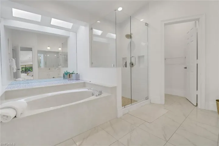Spacious Primary Bathroom with wonderful soaking tub and custom walk-in shower, sky lights recessed lightingprivate water closet