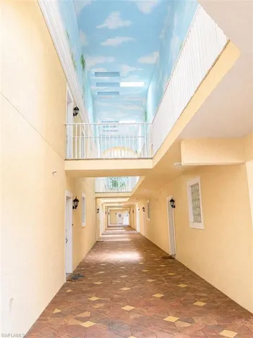 Corridor with patterned tile flooring and light-colored stucco walls