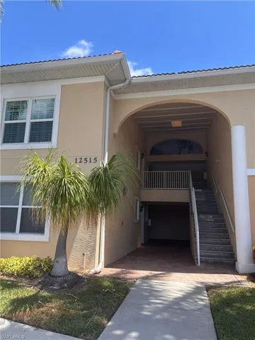 Two-story residential building with a tile roof and stucco exterior