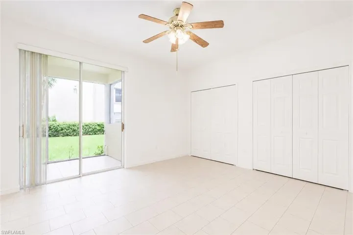 Light-toned tile flooring extends through this room, featuring a ceiling fan with integrated lighting