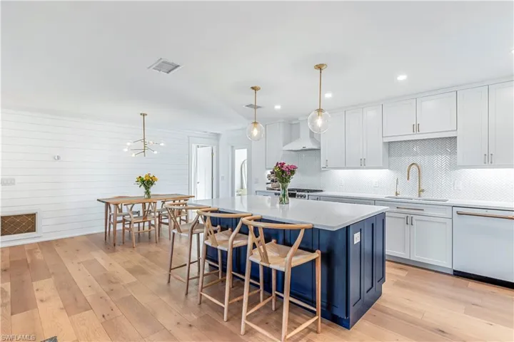 Kitchen featuring pendant lighting,  light hardwood floors, and white cabinetry
