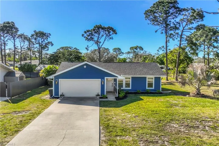 Single story home featuring a front yard and a garage
