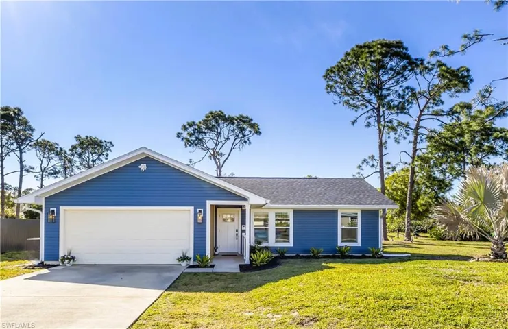 Ranch-style home featuring a front lawn and a garage