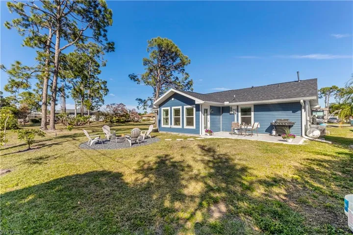Rear view of house with a yard and a patio area