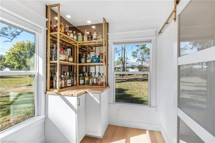 Built in Corner Bar  - Lazy Susan in cabinet, glass shelves & mirror backdrop.