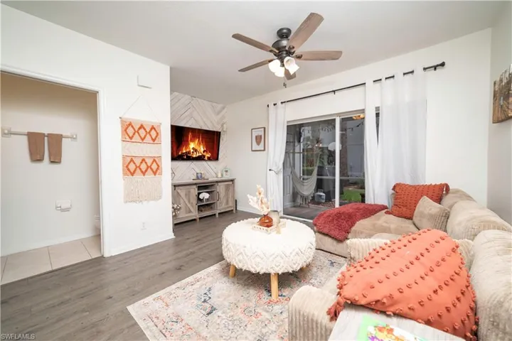 Wood-finish flooring throughout, ceiling fan with integrated lighting, and sliding glass doors to outdoor area
