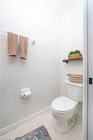 Ceramic tile flooring, toilet, and wall-mounted towel bar