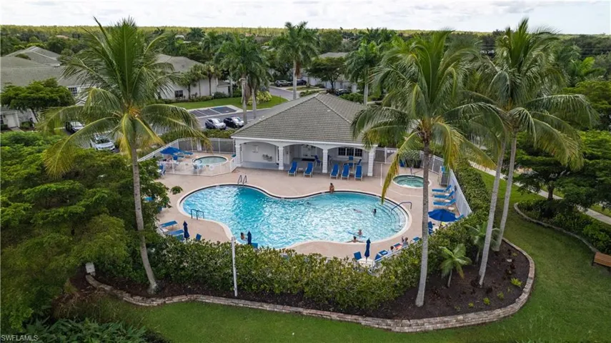 Resort-style pool with integrated spa and sun shelf, surrounded by a paved deck
