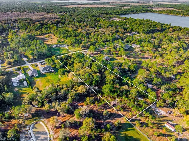 Aerial view of property and surrounding area with property boundaries highlighted and a forest