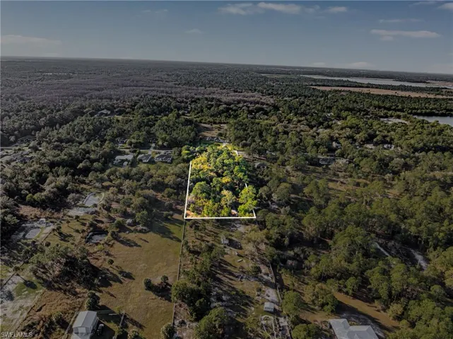 Aerial view of property's location featuring property boundaries highlighted and a heavily wooded area
