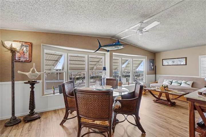 Dining area with fan, a textured ceiling, and light wood-type area showing off the updated  flooring