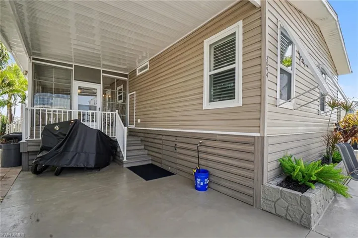 View of patio with area for grilling and storage area for your motorcycle or golf cart.