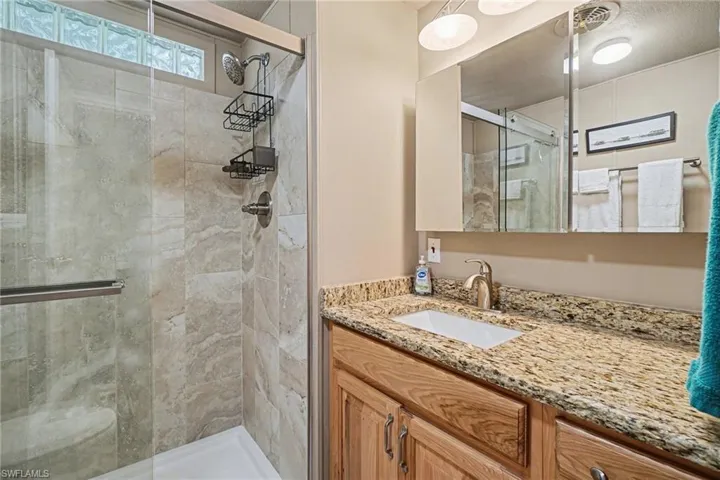 Full bathroom featuring a stall shower and vanity