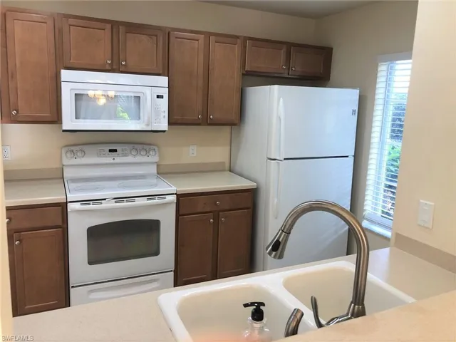 The kitchen has a pantry for storage and all appliances including a dishwasher and microwave