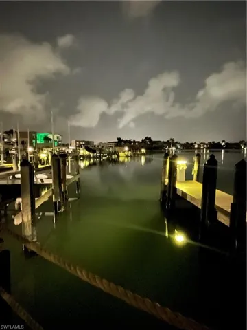 View of dock at night with a water view