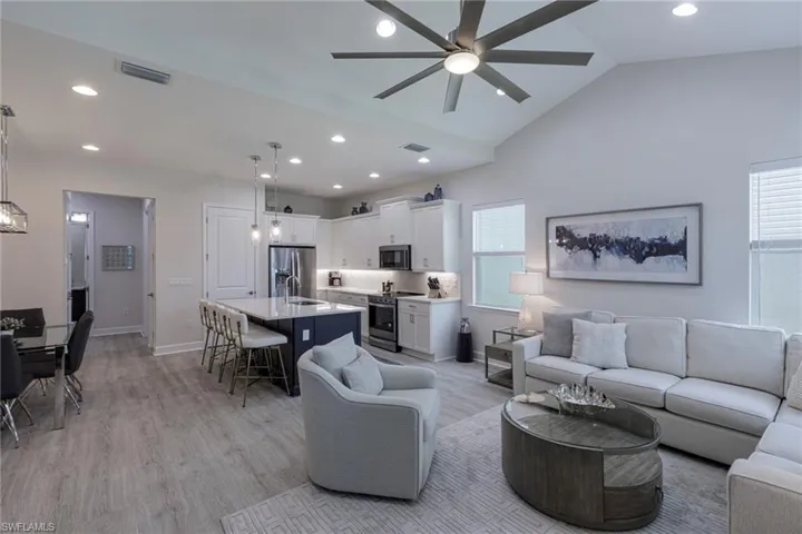 Living room featuring a healthy amount of sunlight, ceiling fan, and light wood-type flooring