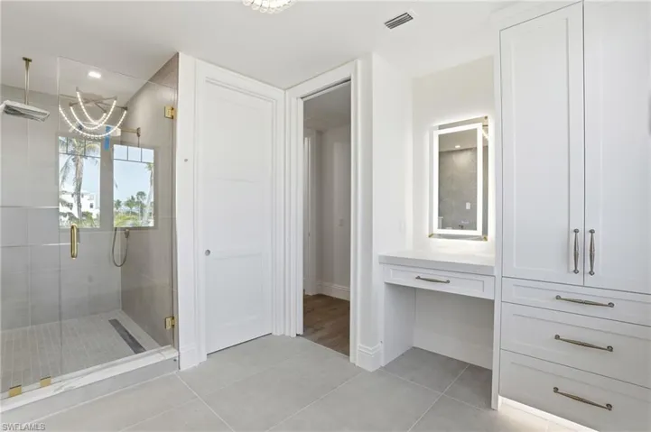 Full bathroom with vanity, light tile patterned floors, and a stall shower
