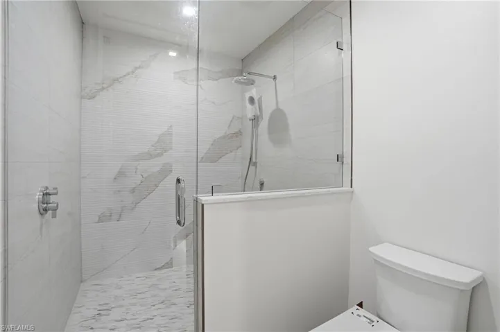 Bathroom with a shower stall and toilet