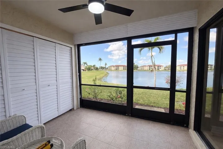 Unfurnished sunroom with ceiling fan and a water view