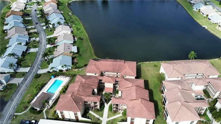 Aerial view of property and surrounding area featuring nearby suburban area and a nearby body of water
