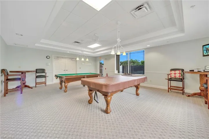 Recreation room featuring a raised ceiling, carpet floors, pool table, and ceiling fan