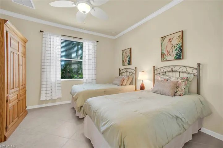 Bedroom with crown molding, tile flooring, and ceiling fan.