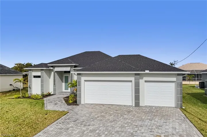 View of front of property featuring a front lawn and a garage