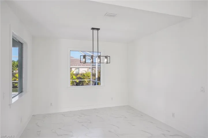 Unfurnished dining area featuring a chandelier
