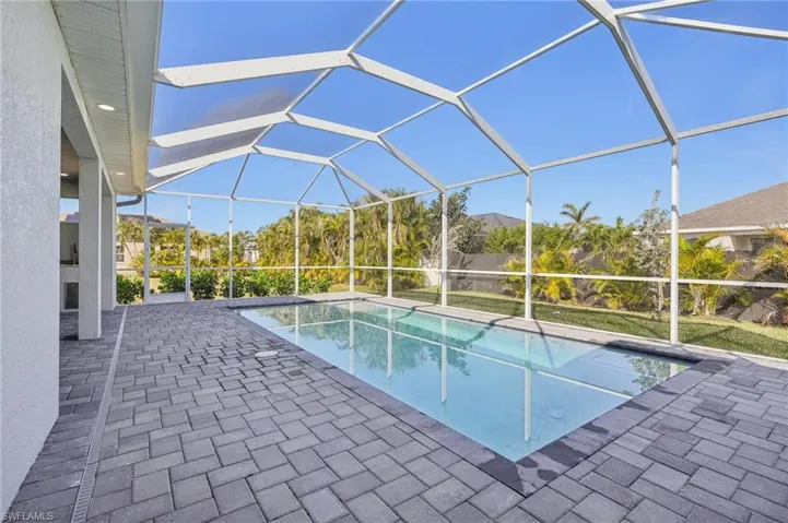 View of swimming pool with glass enclosure and a patio area