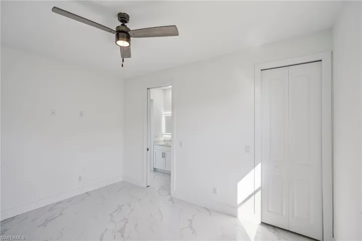 Unfurnished bedroom with ceiling fan and a closet