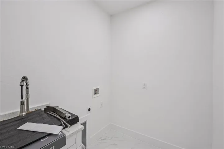 Clothes washing area featuring hookup for an electric dryer and washer hookup