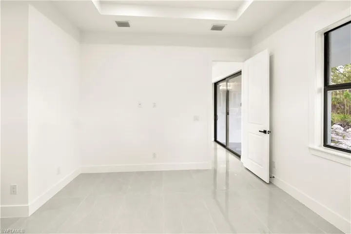 Unfurnished room featuring light tile patterned floors and a raised ceiling