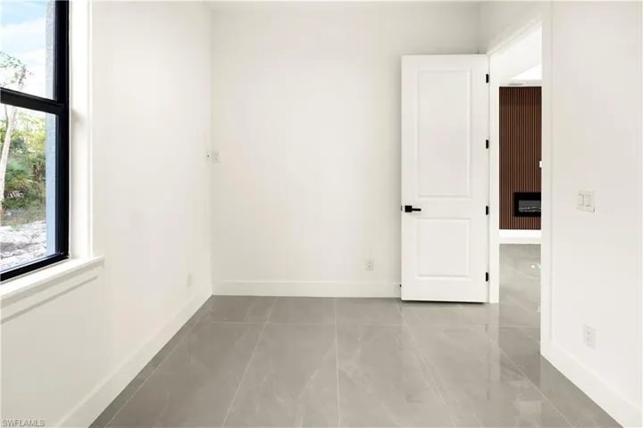 Unfurnished room featuring tile patterned flooring and baseboards