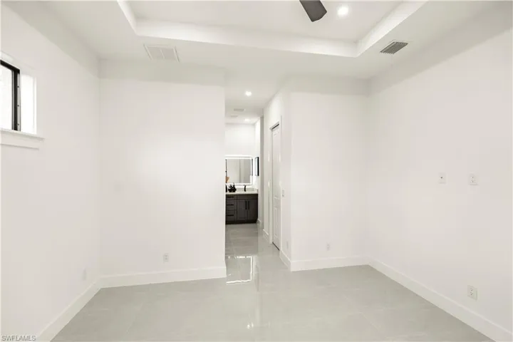 Unfurnished room with light tile patterned flooring, recessed lighting, a raised ceiling, and a ceiling fan