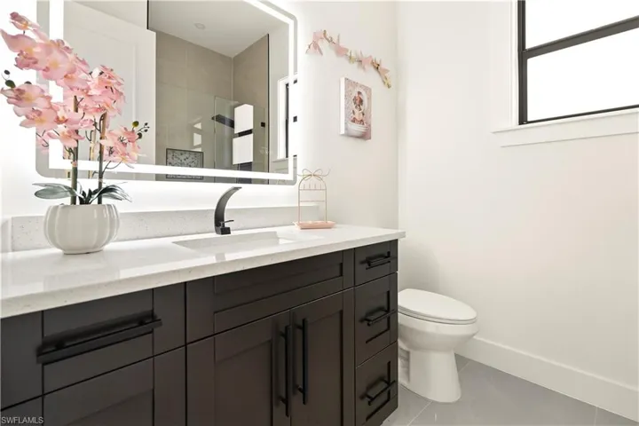 Full bathroom featuring light tile patterned flooring, vanity, and a shower