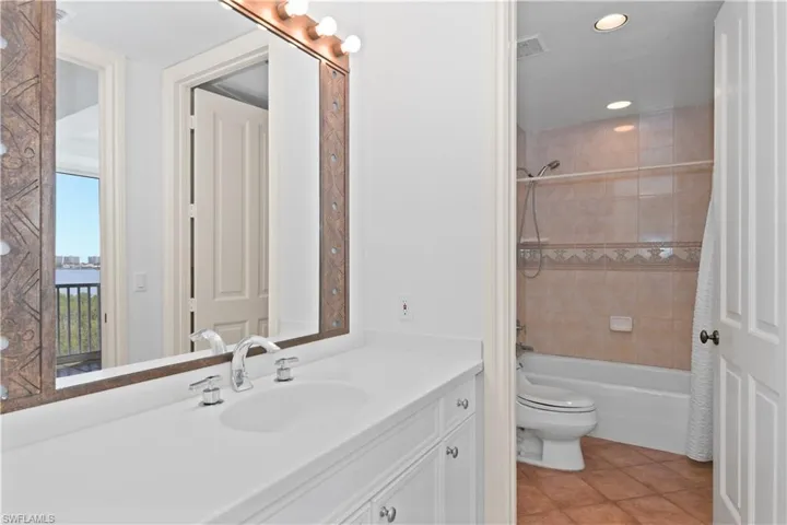 Third bathroom with tile patterned flooring, toilet, shower / tub combo, and vanity