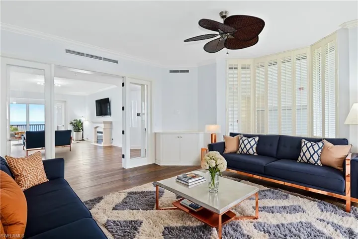 Family room with hardwood floors, ceiling fan, and ornamental molding