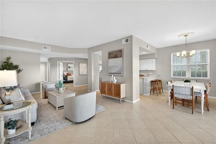 Living area featuring light tile patterned floors and a chandelier