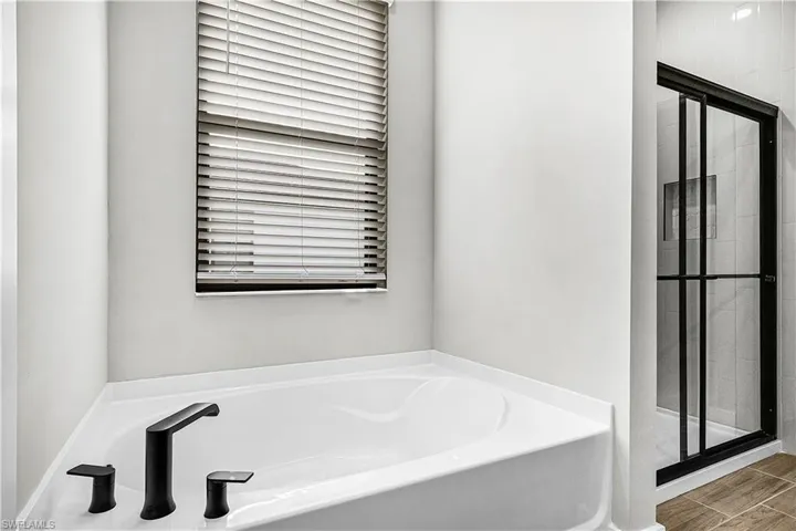 Bathroom with a bath, a shower stall, and wood tiled floors