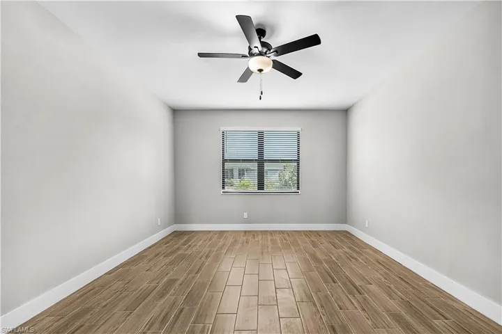 Spare room featuring wood tiled floors and a ceiling fan