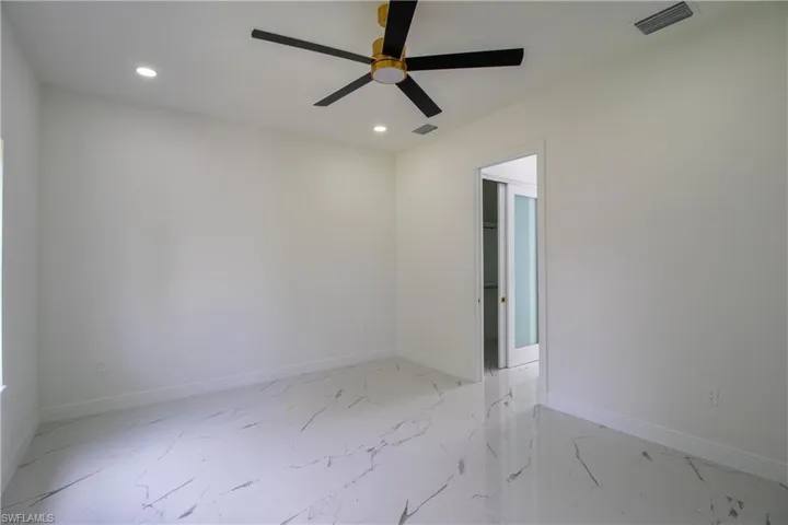 Unfurnished room featuring ceiling fan and light tile patterned flooring