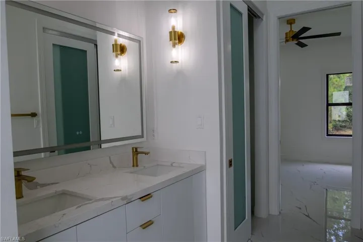 Bathroom featuring ceiling fan and double vanity