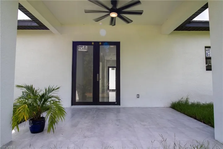 View of exterior entry featuring ceiling fan, french doors, and a patio area