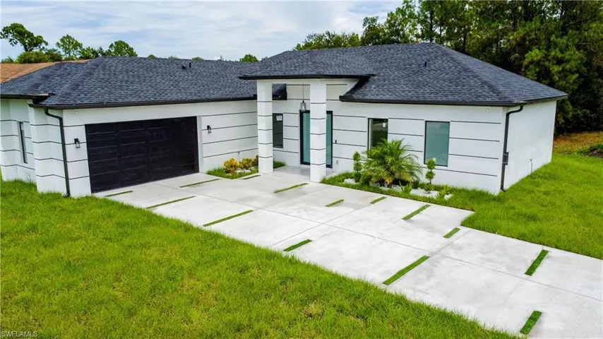 View of front of home featuring a front lawn and a garage