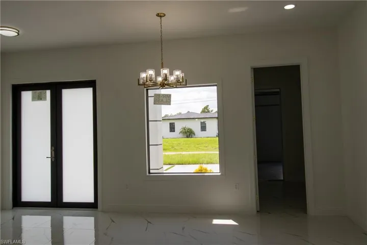 Unfurnished dining area featuring light tile patterned floors and a notable chandelier