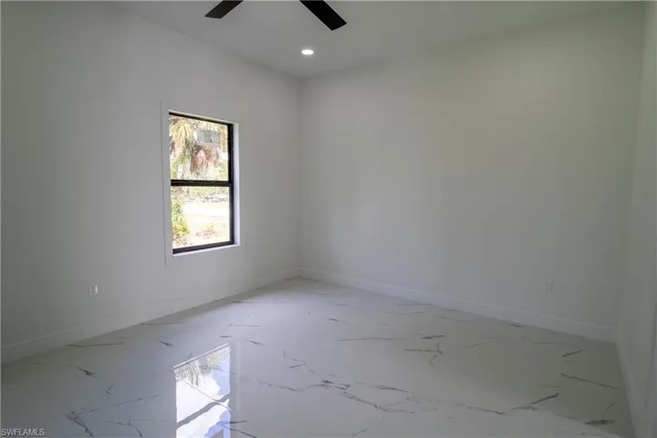 Tiled spare room with ceiling fan