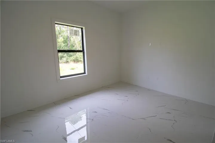 Tiled spare room with a wealth of natural light