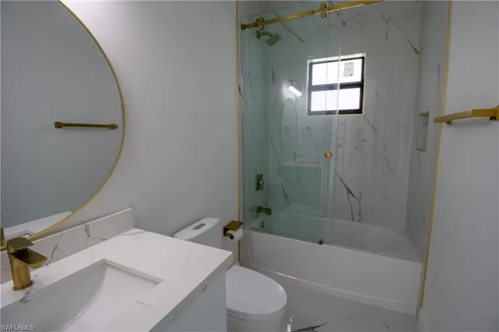 Full bathroom featuring toilet, vanity, tiled shower / bath, and tile patterned floors