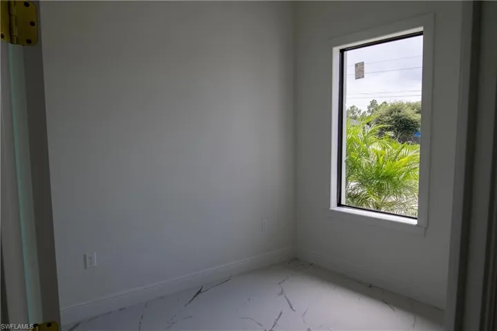 Empty room featuring tile patterned flooring and a healthy amount of sunlight