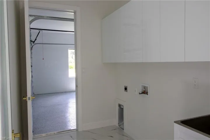 Laundry room featuring washer hookup, light tile patterned floors, cabinets, and hookup for an electric dryer